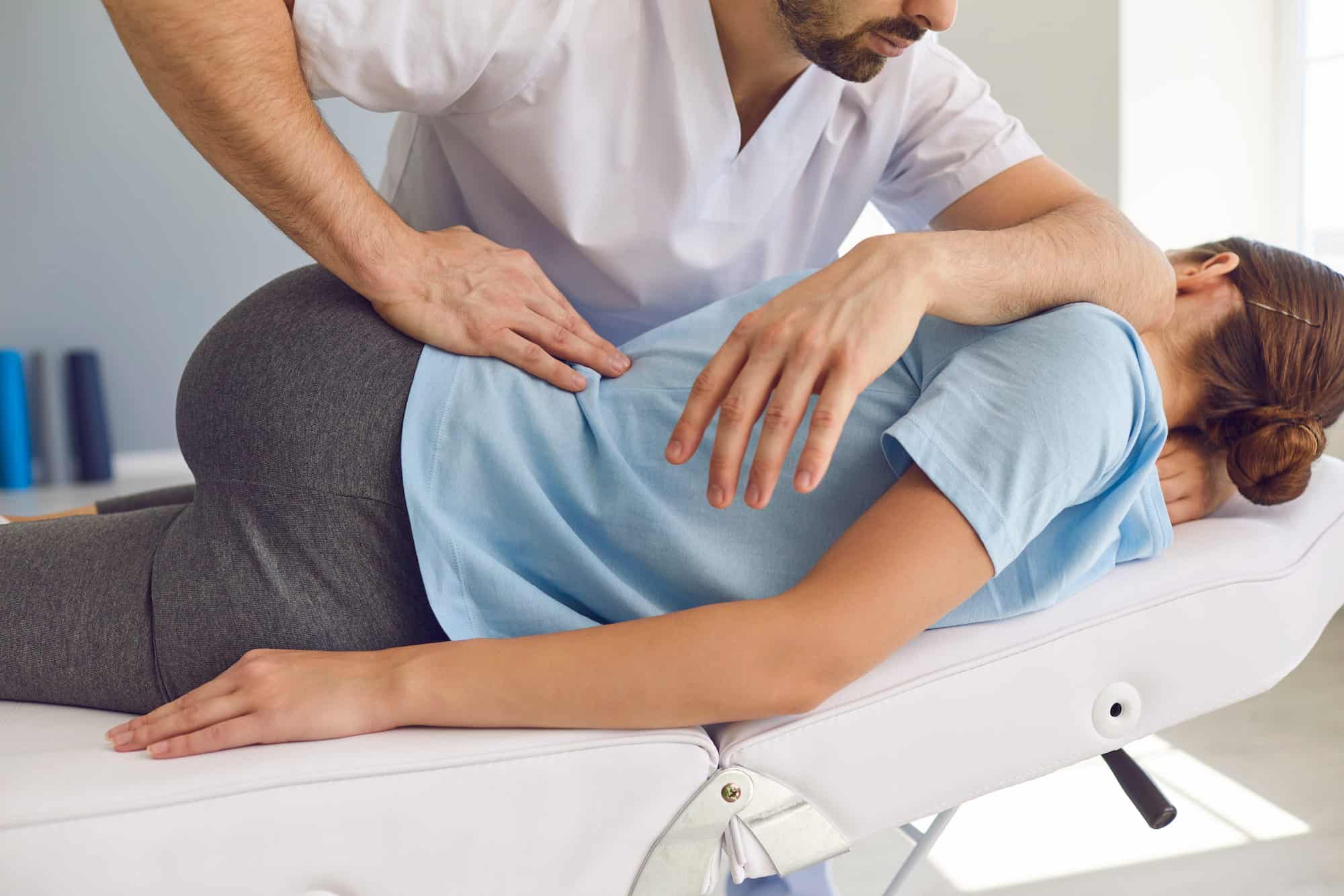 Chiropractor treating a patient on a clinic table
