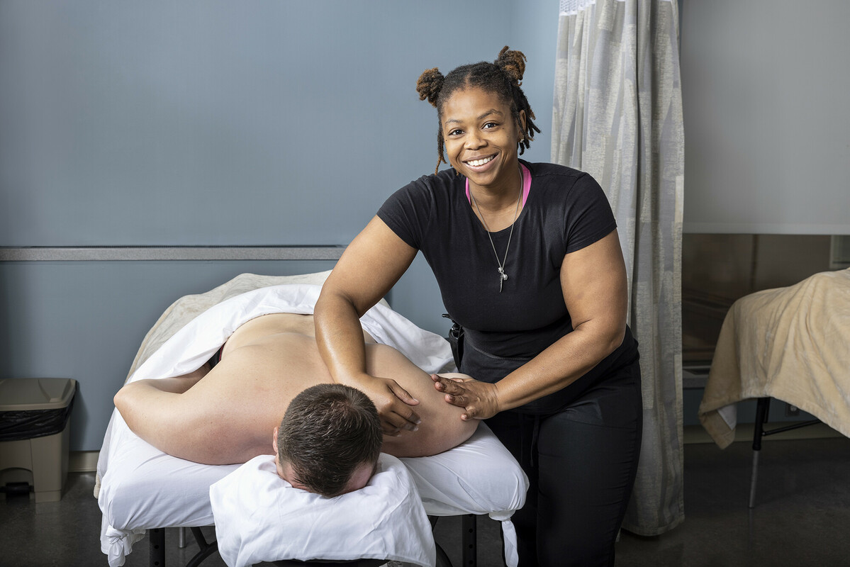 Massage therapist working with a client in a treatment room