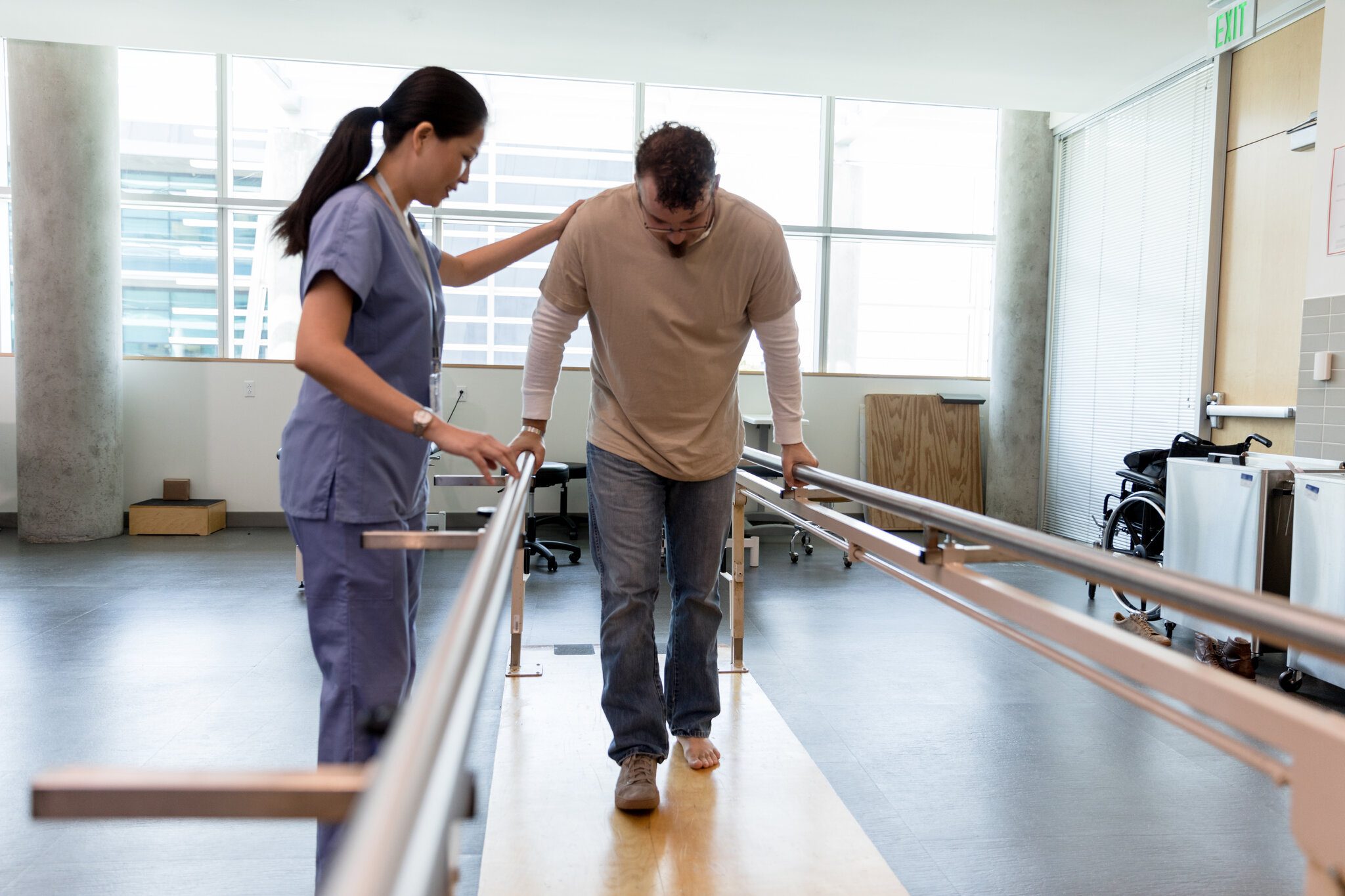Physical therapist helping a patient walk in a clinic