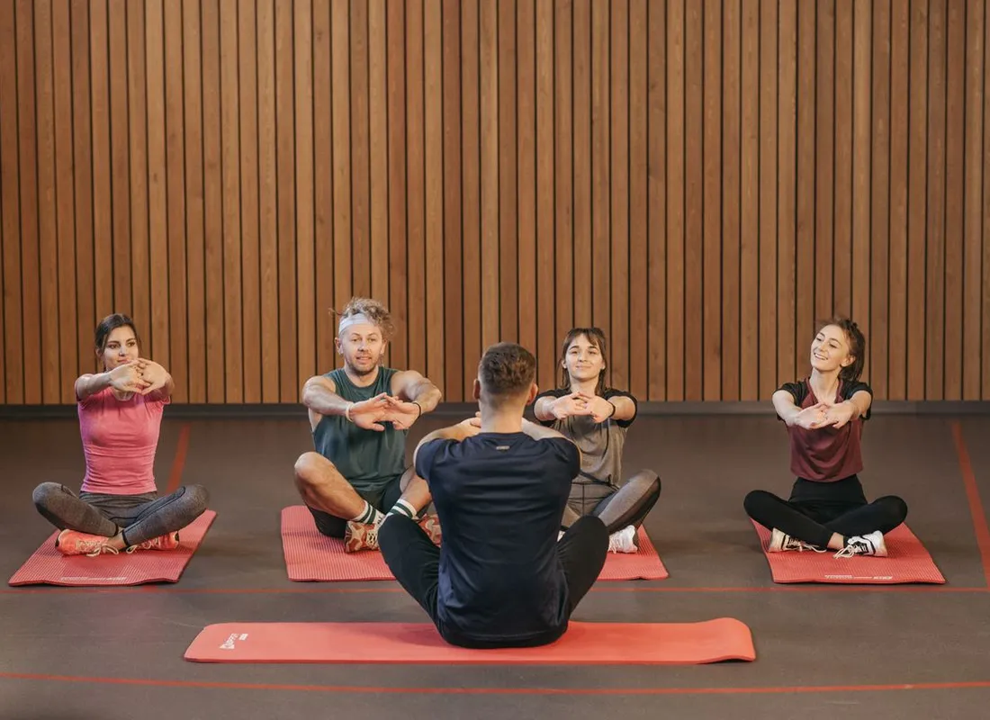 Instructor leading a group movement class in a bright studio
